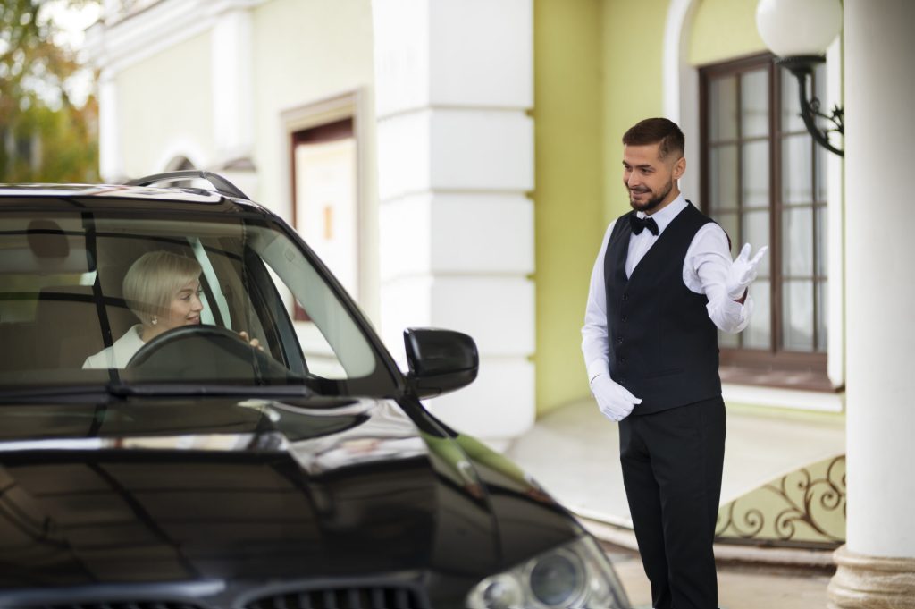 parking-valet-welcoming-woman-with-car-scaled